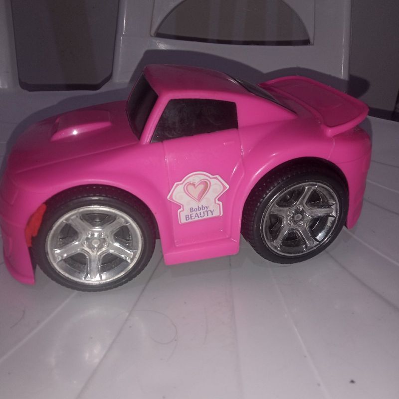 Um caminhão de brinquedo rosa com a palavra kodak na frente