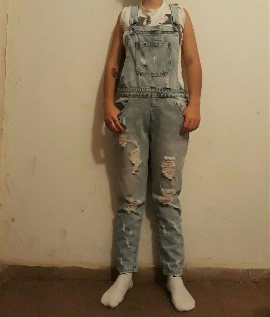 jardineira jeans rasgada