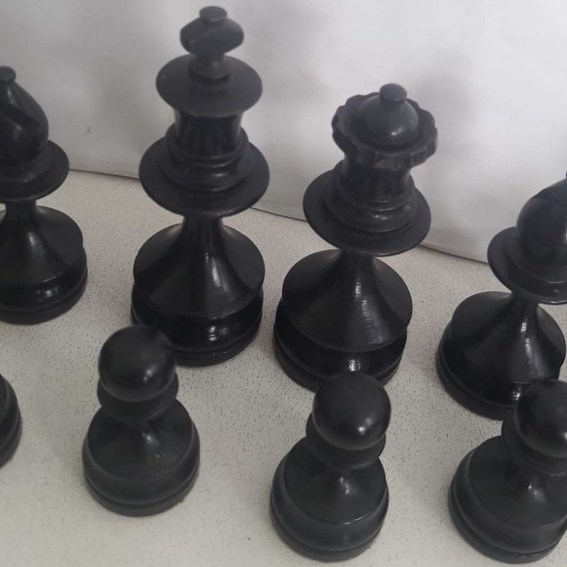 Vista superior do antigo tabuleiro de xadrez com um conjunto de peças de  madeira pretas e brancas em uma posição caótica