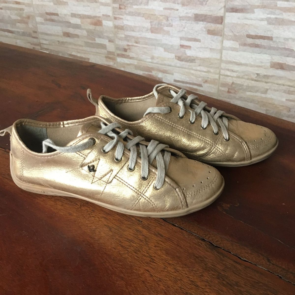 tenis dourado cravo e canela