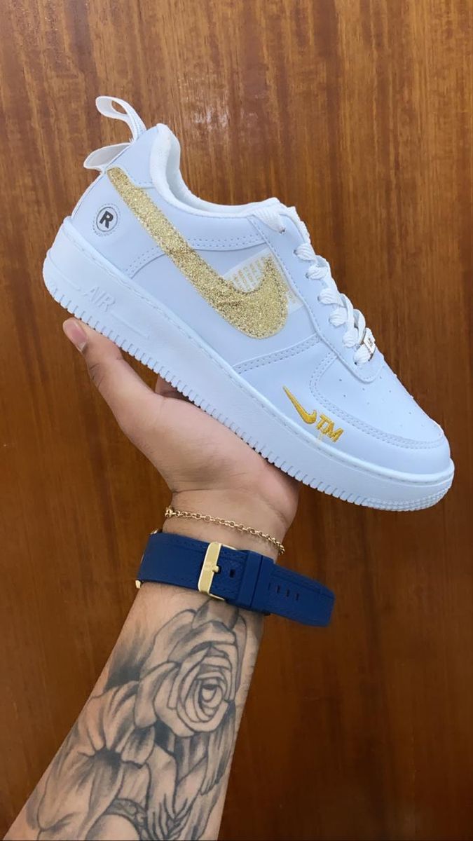 tenis nike branco com simbolo dourado