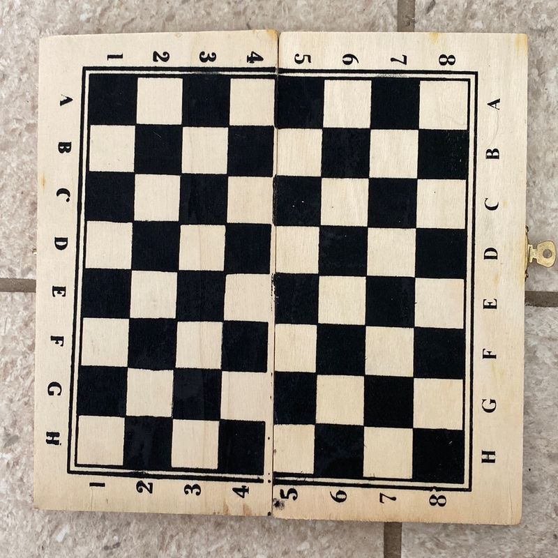 Peças de madeira brancas e pretas em um tabuleiro de xadrez