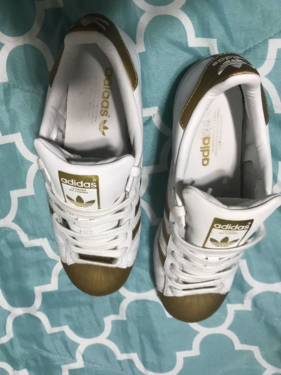 tenis branco com listra dourada
